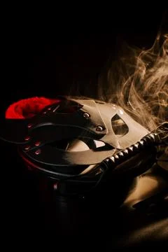 BDSM mask resting on a dark surface with subtle hints of smoke Stock Photos