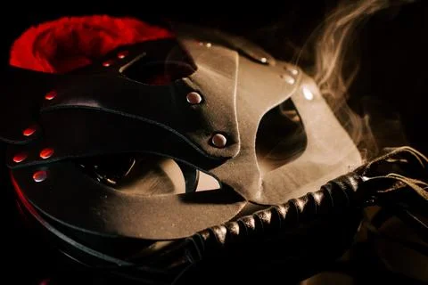 BDSM mask resting on a dark surface with subtle hints of smoke Stock Photos
