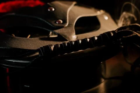 BDSM mask resting on a dark surface with subtle hints of smoke Stock Photos