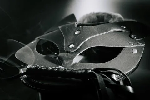 BDSM mask resting on a dark surface with subtle hints of smoke Stock Photos