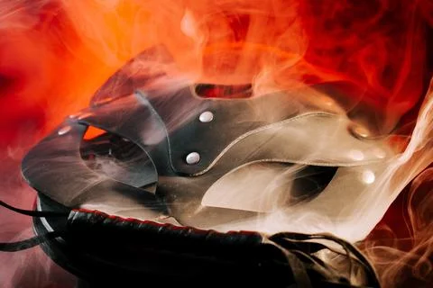 BDSM mask resting on a dark surface with subtle hints of smoke Stock Photos