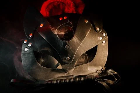 BDSM mask resting on a dark surface with subtle hints of smoke Stock Photos