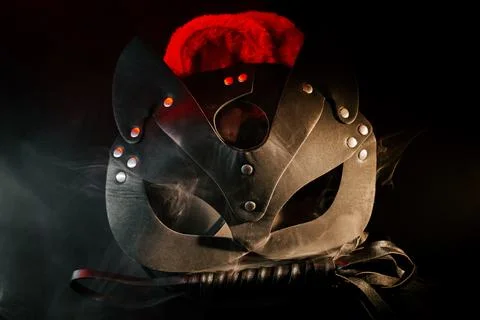 BDSM mask resting on a dark surface with subtle hints of smoke Stock Photos