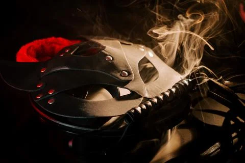 BDSM mask resting on a dark surface with subtle hints of smoke Stock Photos