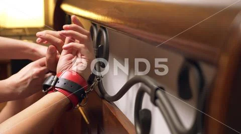 BDSM, sex toys. romantic couple in bed. the hands are handcuffed to the wrought Stock Photos
