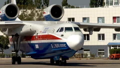 Be-200ES multi-purpose amphibious aircraft slowly moves from parking lot to sea. Stock Footage 121532805