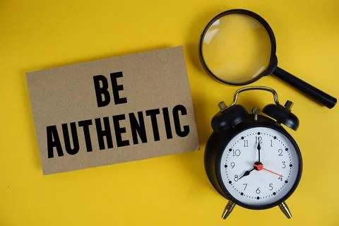 Be Authentic text written on paper with magnifying glass and alarm clock on.. Stock Photos