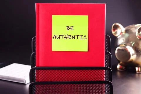 Be Authentic text on a yellow sticker glued to a red business notebook on a.. 写真素材