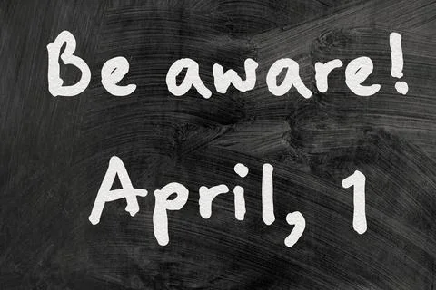 Be aware on blackboard note over a dark background. april fools day Stock Photos