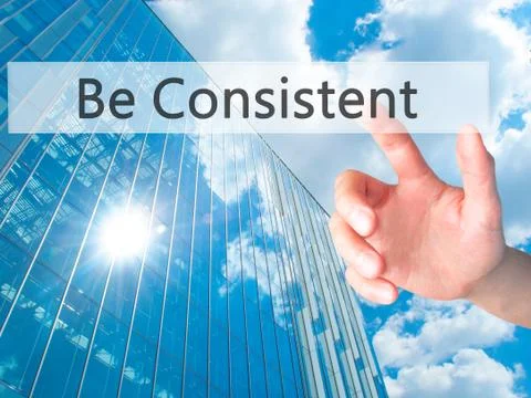 Be Consistent - Hand pressing a button on blurred background concept on visua Foto stock