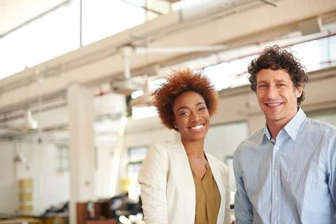 Be devoted to your goal. Portrait of two coworkers standing in an office. Stock Photos