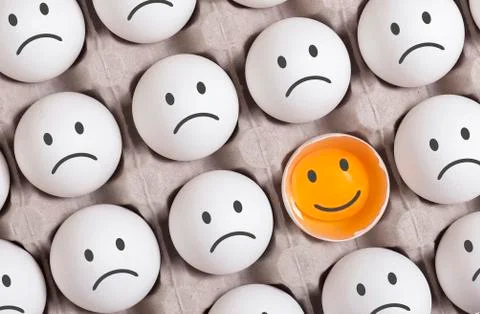 Be different concept. smiling face among group of sad faces Stock Photos