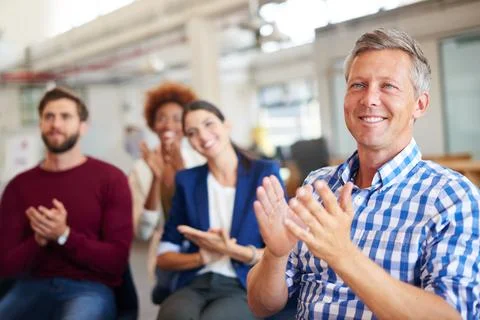 Be eager to know. A group of colleagues applauding a work presentation. Foto stock
