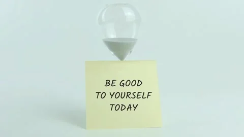 Be Good to Yourself written on yellow sticky note placed on hourglass Stockbeeldmateriaal 313482234