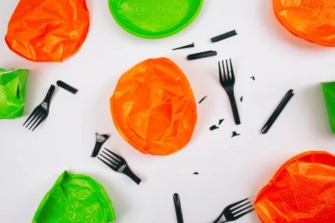 Be plastic free. Single-use colorful broken plastic plates and forks on a white Stockfoto's