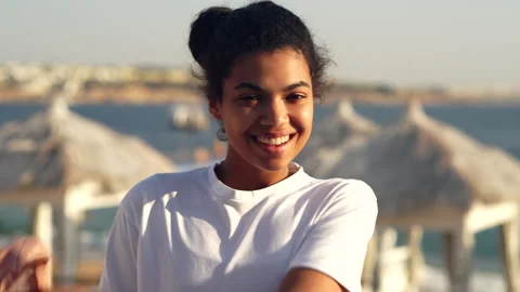 Be positive. Close up of joyful young woman smiling at camera while taking off Stock Footage 149436010