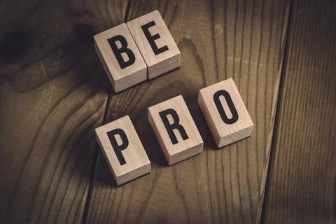 Be pro. Wooden Message on Rustic Table Foto stock