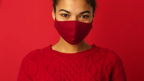 Be protected. Young mixed race girl putting on protective face mask and then Stock Footage 146129759