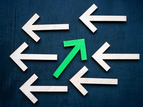 Be unique and different abstract. Wooden arrows in one direction and green in Stock Photos