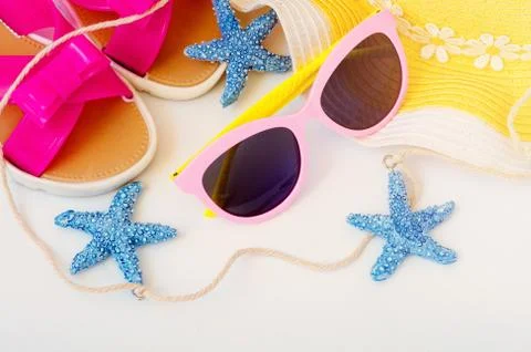 Beach accessories. Flip flops, hat and starfish on white background. Top view Stock Photos