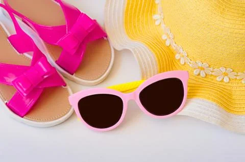 Beach accessories with straw hat, glasses, shawl and flip flops on white Stock Photos