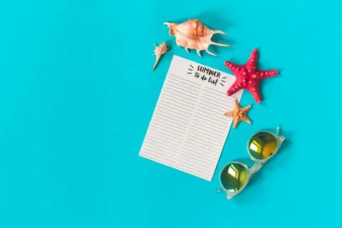 Beach accessories with summer to do list notebook, sunglasses, sea shell and Stock Photos