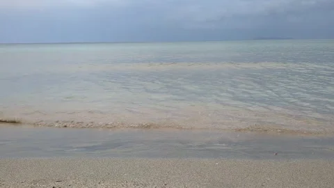 Beach after sunset, legs of two men walking on the beach cloudy weather and calm Stock Footage 312622241