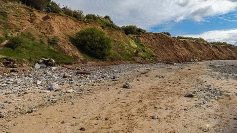 Beach and cliffs with a blue cloudy sky Stock Photos