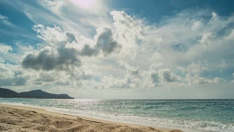 Beach and mountains behind. From the clouds make their way rays of the sun Stock Footage 82788878