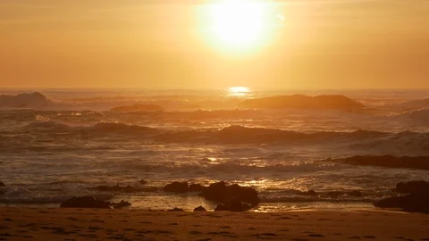 Beach and Ocean at sunset with soft golden light and sun glinting on water Stock Footage 103116819