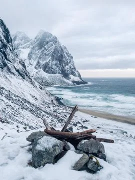 Beach and ocean surrounded by mountains during winter in Kvalvika Beach Stock Photos