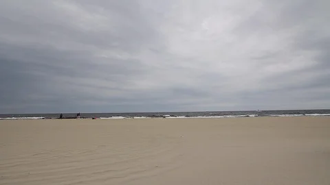 Beach and ocean view with overcast sky few people in far away left Video stock 92549265