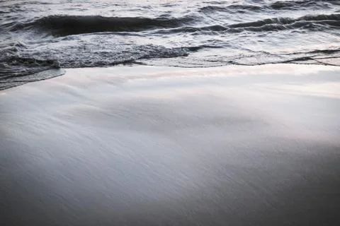 Beach and wave motion blur and sand black and white effect filter with grain  Stock Photos