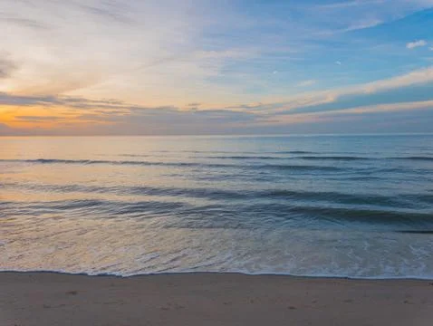 Beach and waves breaking on the shore at summer sea Stock Photos