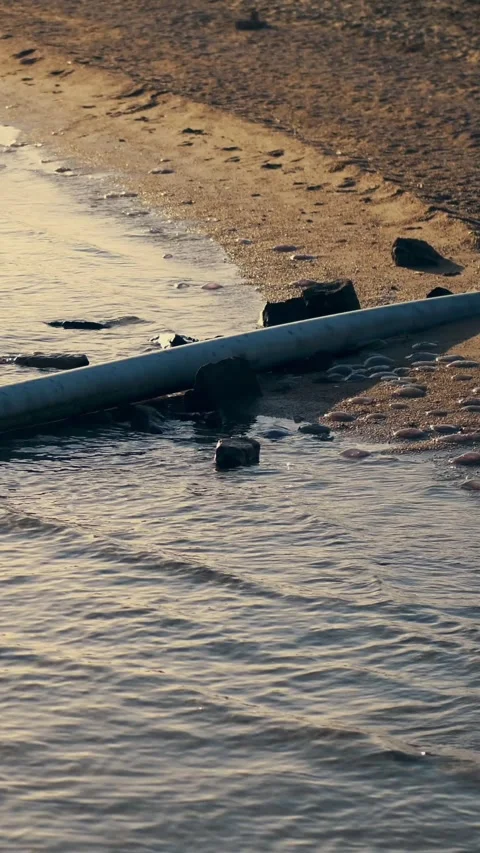 From the beach area to the sea, a sewer pipe is being displayed. hotel complex Video stock 311638234