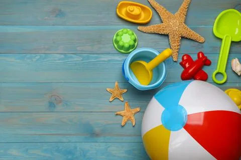 Beach ball and sand toys on light blue wooden background, flat lay. Space for 写真素材