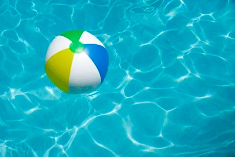 Beach ball floating in pool Stock Photos