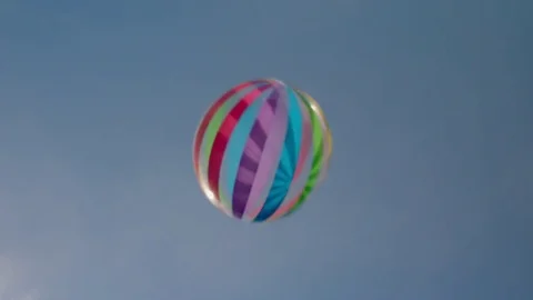 Beach ball flying through blue sky - handheld - slow motion 02/02 Stock Footage 80757343
