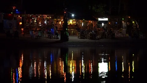 Beach bar, coconut palm tree and night club is reflected in sea water, Thailand Stock Footage 107501772
