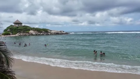 Beach Bay View with Thatched Lookout and Swimmers Stock Footage 342571438