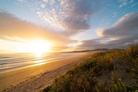 A beach with a beautiful sunset in the background Stock Photos