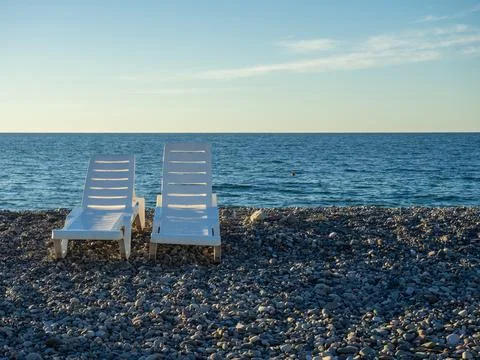 Beach beds. Folded beds. End of the season. On the Sunset. Beach vacation. Stock Photos