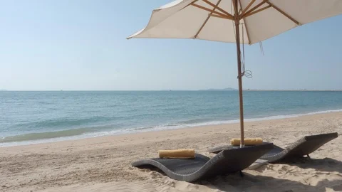 Beach beds with umbrella on sand and sea with blue sky (original sound) Stock Footage 103333497