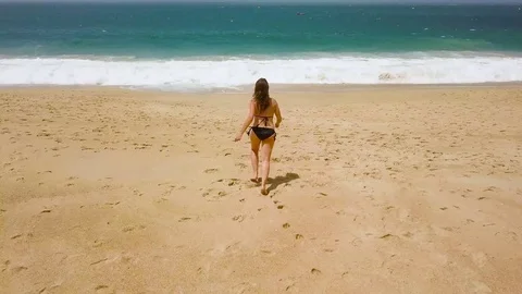 Beach bikini woman carefree running to the water on the beach. Picturesque ocean Stock Footage