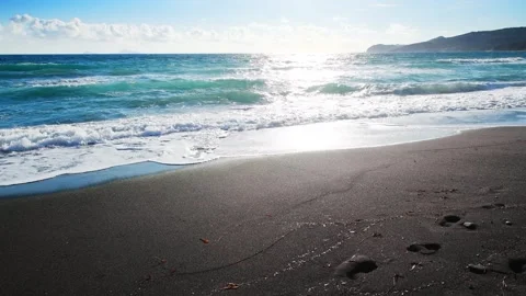 Beach with black volcanic sand and the blue sea at sunset. Stock Footage 271468686