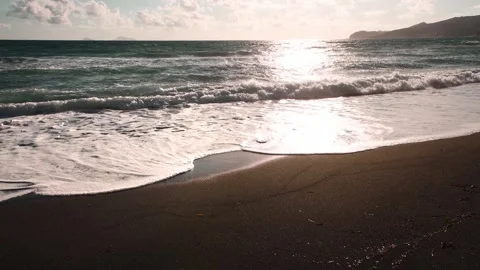 Beach with black volcanic sand at sunset. Vlichada beach in Santorini, Greece. Stock Footage 242162138