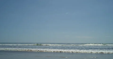 Beach with blue sky and waves rolling onto shore 스톡 동영상 138288537