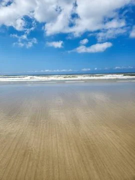 Beach with Blue Sky and Waves Stock Photos