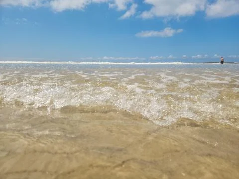 Beach with Blue Sky and Waves Stock Photos