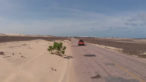 Beach Buggy driving towards drone on long desert road 스톡 동영상 196887679